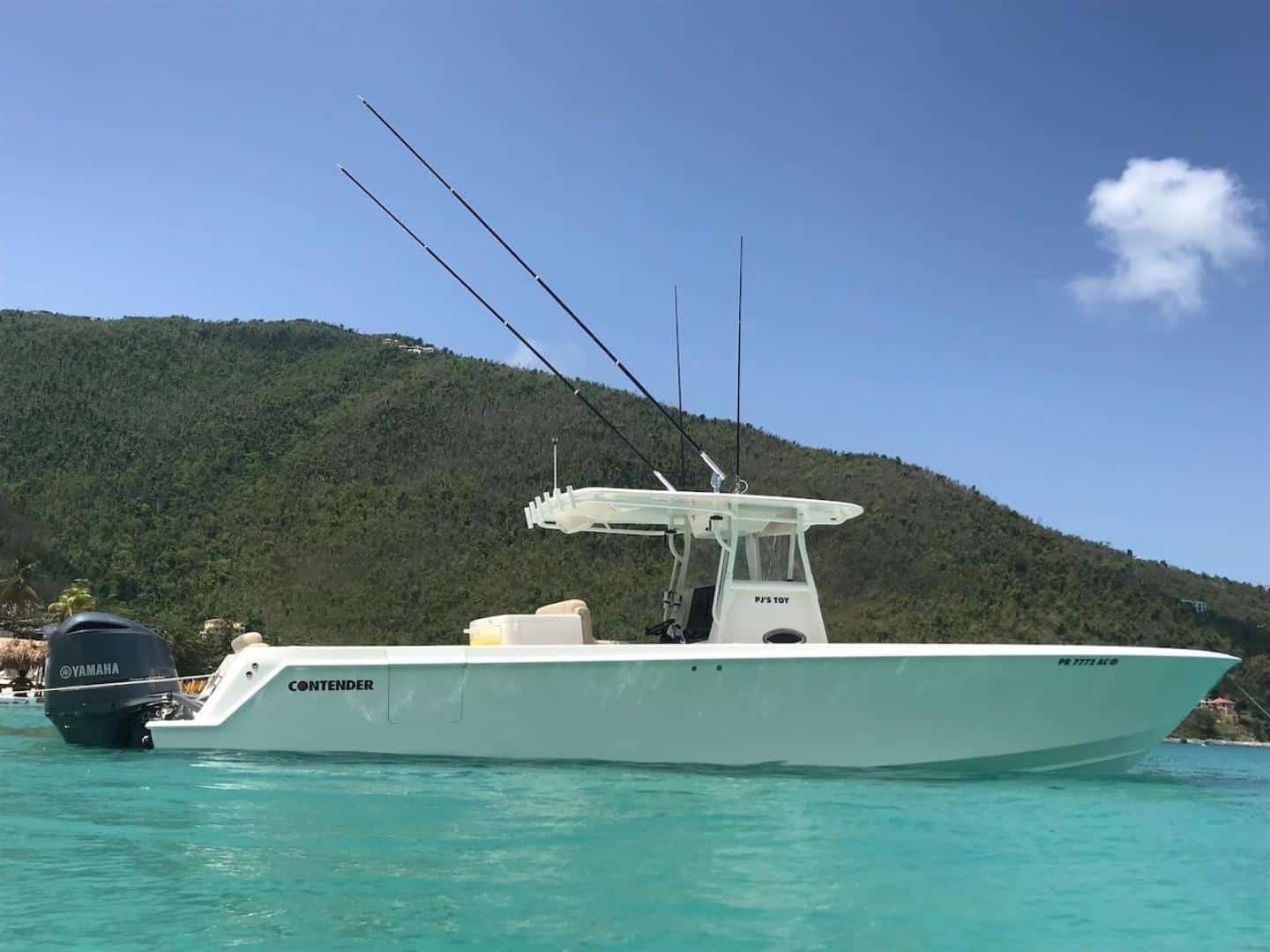 Bateau de pêche sportive Contender 39 avec tangons, au mouillage dans une eau turquoise